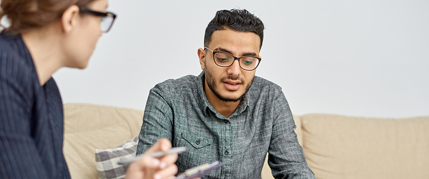 Man talking to woman in counseling session.